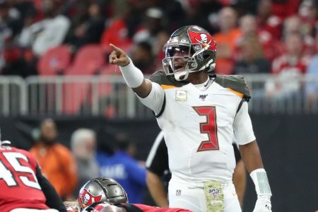 Jameis Winston in a white kit poses a picture.